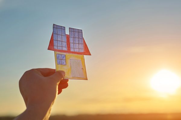 House is painted on paper with solar panels. Solar energy panel concept. Alternative energy.